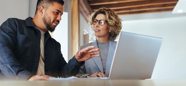 Two employees chat with laptop